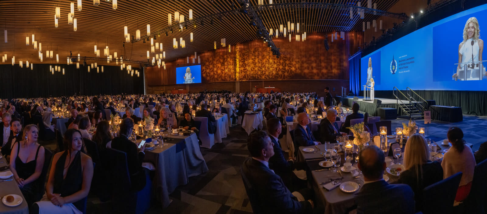 A wide view of the ballroom, hanging lantern lights, before the speech